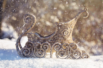 Golden sleigh in the snow. Christmas toys.