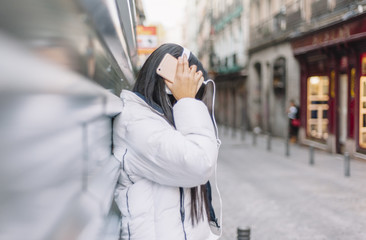 Fototapeta premium attractive chinese woman with headphones and telephone