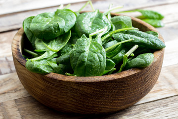 Fresh baby spinach in a wooden bowl