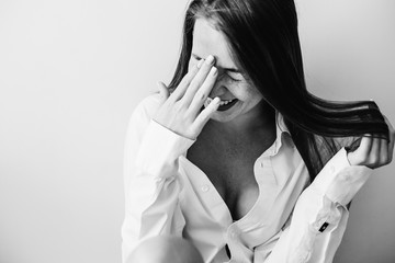 Cheerful girl in a white, open shirt, with a beautiful face and