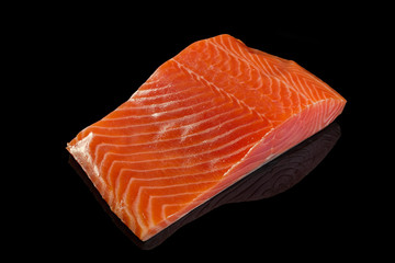 Fresh slice salmon fillet steak isolated on black background with reflex