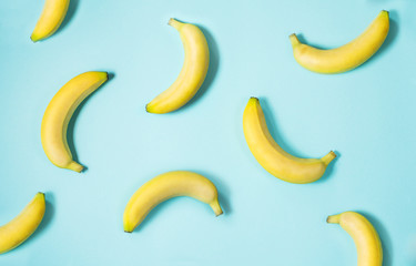 Top view of fresh yellow bananas isolated on blue background