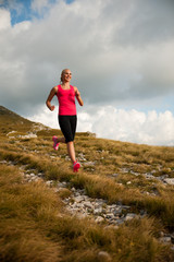 Naklejka na ściany i meble runner - woman runs cros country on a path in early autumn