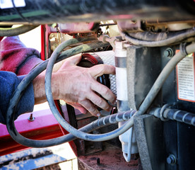 Obraz premium Mechanic installing new air filter in large tractor 