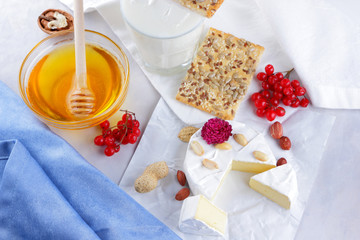 Cheese on white background, camembert, a glass of milk, Christmas cheese with honey, white background, blue napkin, pop art, red berries, Mexican cuisine, Indian cuisine, French breakfast