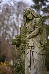 Obraz premium Old statue on a closed graveyard