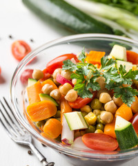 Detail of homemade chickpea vegetable salad on white background.