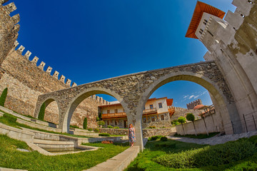 Fototapeta premium Young woman tourist against massive walls of Rabati Castle