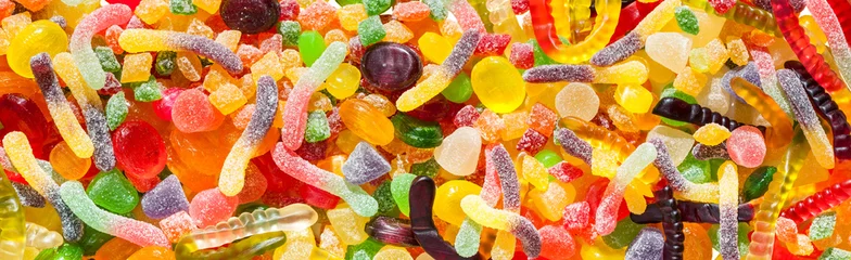 Fototapeten Panorama hautnah einen Hintergrund aus bunten Süßigkeiten von Zuckerbonbons und Marmelade. © yanikap