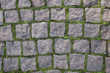 Fragment of the old road paved granite stones