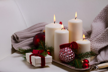 White glowing advent candles with christmas decorations