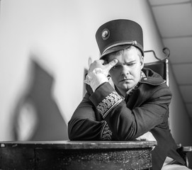 Actor dressed historical costume in interior of old theater. Black-white portrait.
