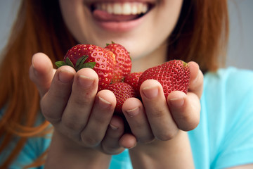 Woman with strawberries on palms close-up