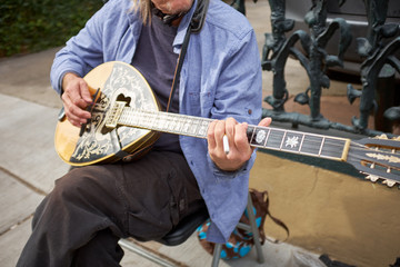 Man sitting and plucking on stringed instrument