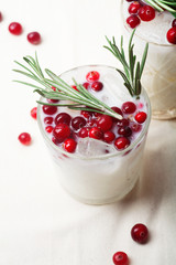 Perfect christmas cocktail: coconut margarita with cranberries and rosemary. Minimalistic concept. Linen cloth and white background. Close up view.