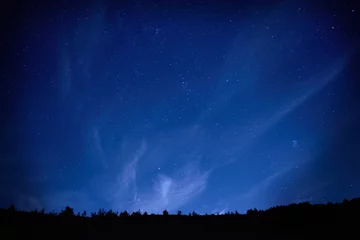 Rolgordijnen Blauwe donkere nachtelijke hemel met sterren. © Pavlo Vakhrushev