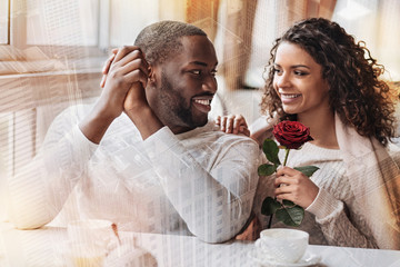 Having a date. Cheerful young couple looking at each other while expressing happiness and delight