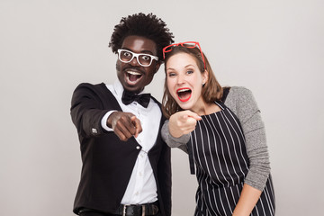 Mock, sneer concept. Colorful couple pointing fingers at camera