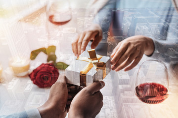 Dreams coming true. Close up of desired present for wonderful woman in hands of young man being in love