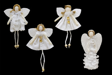 Christmas and New Year decorations for the Christmas tree: white figures of angels in the style of handmade. Isolated, black background.