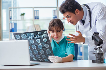 Obraz premium Two doctors discussing x-ray MRI image in hospital