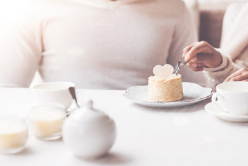 Try it. Female hand holding fork in right hand while beginning to eat sweets, being in cafe