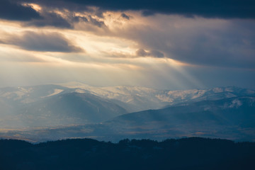 Rays of light pass through the clouds, mountain landscape