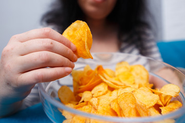 Fat woman reaching to chips. Unhealthy eating, bad habits, food addiction, junk food concept