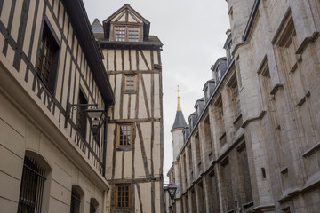 Fototapeta na wymiar Old and tilted houses at Rue Eau de Robec in Rouen on a rainy day. Rue Eau-de-Robec is one of the main tourist streets of Rouen. Upper Normandy, France.