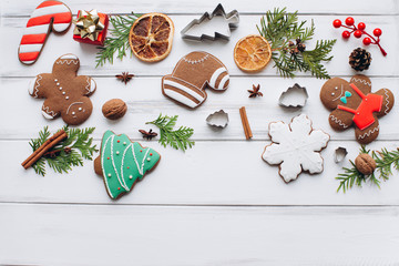 Homemade delicious Christmas gingerbread cookies on the white wooden background.