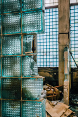 Fototapeta premium Fragment of broken wall from glass blocks in abandoned industrial building