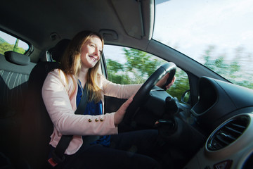 Naklejka premium Young woman driving a car