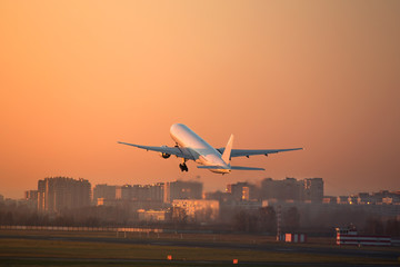 airplane take-off on sunset above the runway /plane fly up at sunset yellow sky background /Lifting force airplane/ 