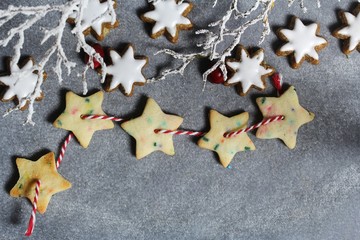 Naklejka na ściany i meble Homemade Xmas garland cookies on festive holiday background with copy space