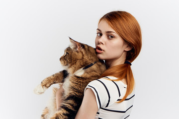 Young beautiful woman on white isolated background holds a cat, pets, animals