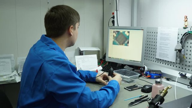 Service center. Electronics repair shops.The repair of the smartphone. Man repairing a smartphone. Electron microscope.