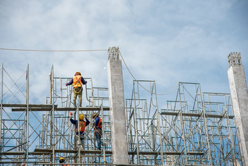 group of worker in safety uniform install reinforced steel column in construction site during...