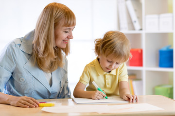 Child drawing with mother