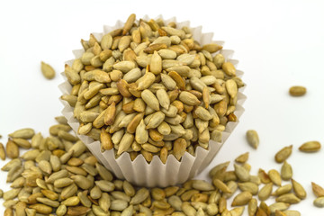 Obraz premium fresh sunflower seeds in paper cup isolated on a white background