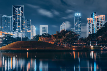 Obraz premium Business district downtown background, skyscrapers reflected in water. Kuala Lumpur City Centre Park at night