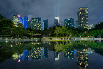 Naklejka premium Business district downtown background, skyscrapers reflected in water. Kuala Lumpur City Centre Park at night
