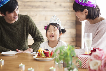 Dad and mommy are celebrating her daughter 's birthday.