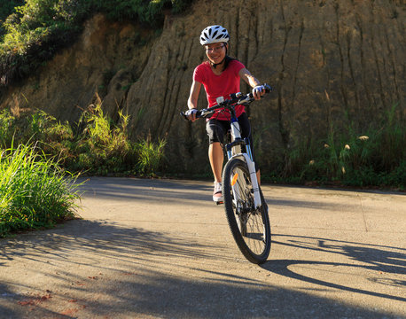 woman cyclist cycling mountain bike on trail