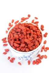 Red dry goji berries in a small cup on a white background   