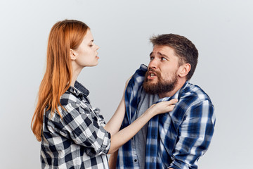 Man with a beard on a white isolated background with a beautiful young woman, emotions