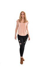 full length portrait of a girl wearing pink shirt and black floral pants. standing pose, isolated on white background.