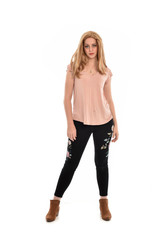 full length portrait of a girl wearing pink shirt and black floral pants. standing pose, isolated on white background.