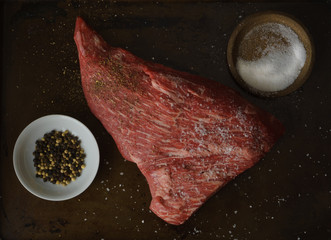 Raw tri-tip roast seasoned with kosher salt and pepper