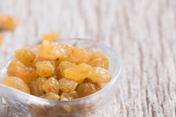 Dried yellow raisin fruits on  wood background