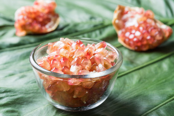 Pink juice pomegranate on leaf background